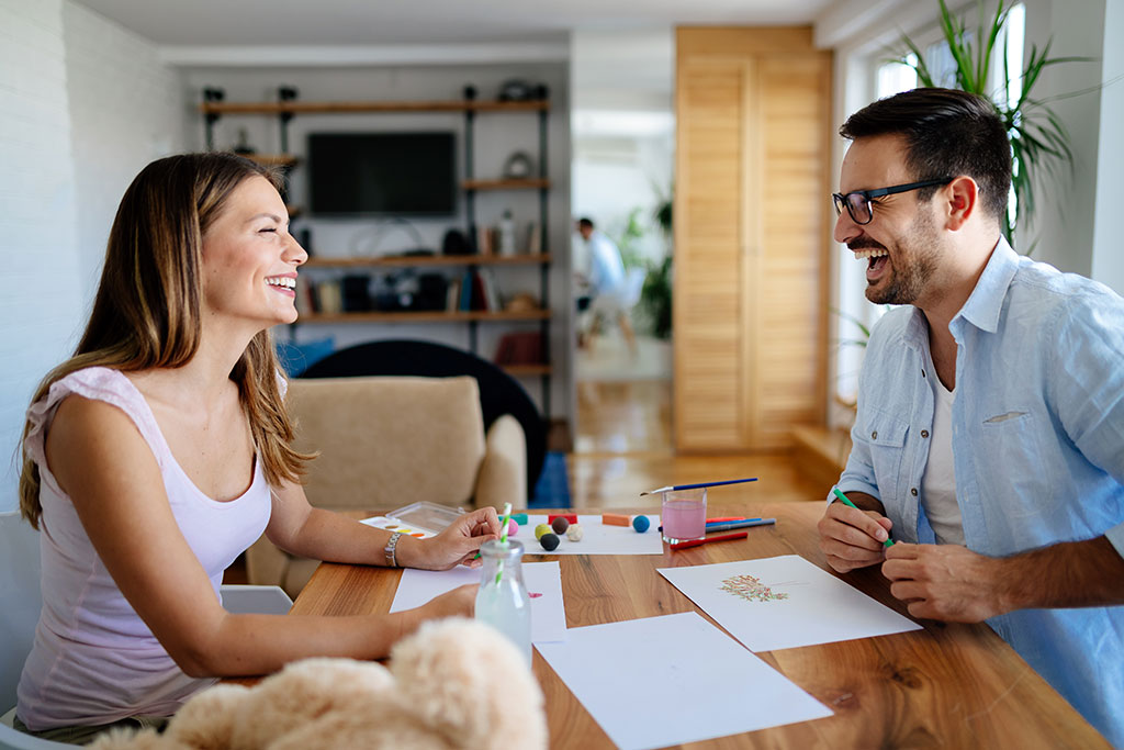 happy couple having fun drawing at home 3MLWZAU